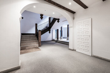 Lobby of a vintage residential apartment building with a large interior atrium and exposed wooden columns and beams