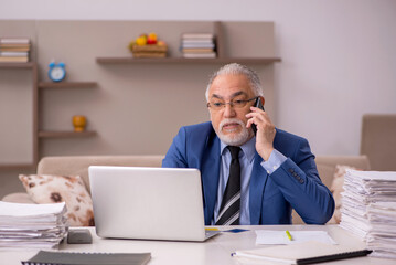 Obraz premium Old male boss working from home during pandemic