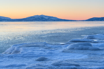 Beautiful winter arctic seascape. Ice-covered seashore and unfrozen water. Ice floes on the coast....