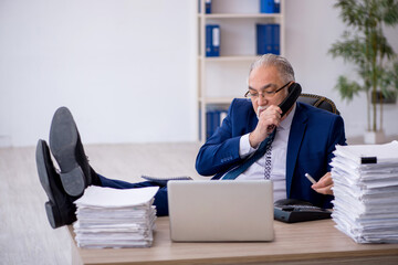 Fototapeta premium Old male employee and too much work in the office