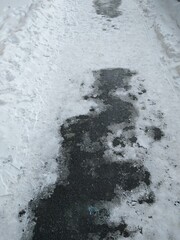 Asphalt path with melted snow close-up. High quality photo