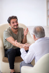 Young man visiting old psychologist