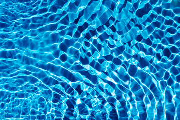 Rippled transparent fresh blue water gel surface in swimming pool with flecks, waves. Relaxation. Copy space background