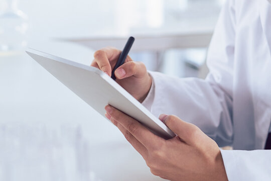 I can mark that off as done. Cropped shot of a unrecognizable scientists hands making notes on a digital tablet inside of a laboratory.