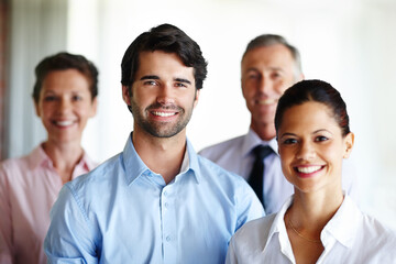 We are a great team. A group of corporate co workers standing alongside each other.