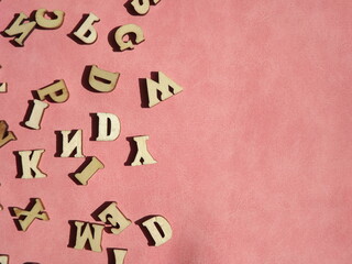 wooden letters of the English alphabet on pink suede as a background. High quality photo