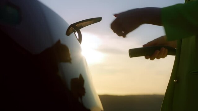 Slow motion woman pulls out power cable 0 emission electric car charging station