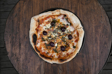 Traditional pizza. Top view of a mozzarella cheese pizza with tomato sauce, black olives and fresh...