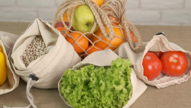 Vegetables in eco zero waste bags. A vegetables fruits and beans in eco friendly meshes on the table in the room.