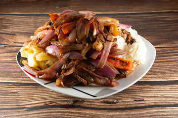 Lomo saltado with beef and Italian tripe with white rice, julienned onions, tomatoes and golden French fries