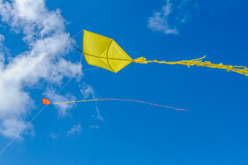 Brazilian kites. Yellow and orange kites in the blue sky.