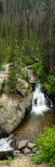 Fototapeta na wymiar Vertical Panorama of Small Waterfall In Rocky Mountain