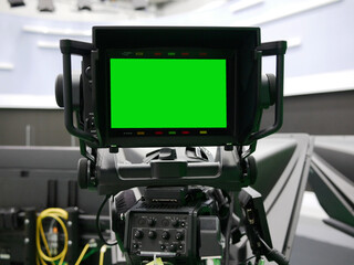 camera monitor of professional studio camera with green screen at TV station.