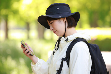 	山でスマートフォンの電波が届かず困る女性
