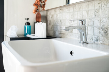 A Faucet with sink installation in bathroom. A faucet is a device that controls the flow of a liquid from a pipe or container.
