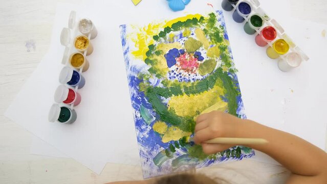 Little girl coloring colorful abstract with flowers. Early development.  Children's creativity . The concept of a happy childhood.