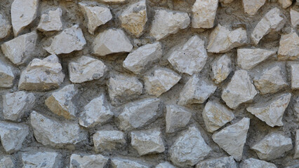Texture of a stone wall made of natural stone with mosaic masonry for background.