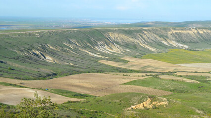 Fototapeta premium Scenic beauty, landscape scene, view of hills and green valleys with blue sky and sea on the horizon.