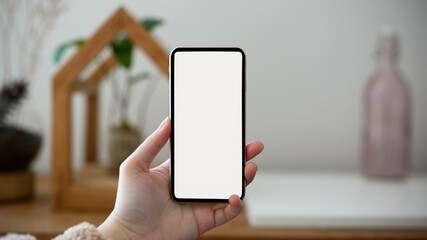 A female hands holding a smartphone white screen mockup