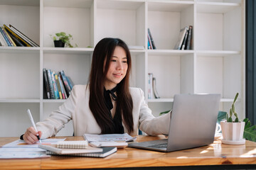 Fototapeta na wymiar business asian woman working with laptop for financial document in office. female accountant doing accounting and calculating. bookkeeper making calculation. Savings, finance
