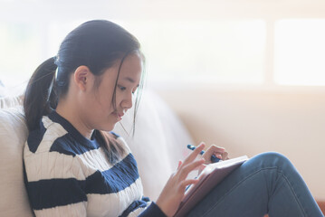 Asian girl drawing picture with digital pen on tablet pc computer