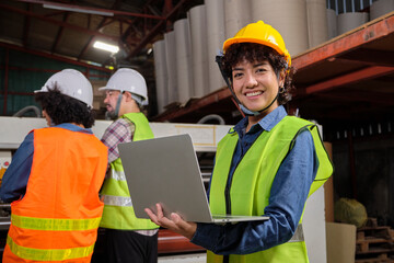 Portrait of safety uniform female engineer worker and hard hat with laptop looks at camera, happy smile and cheerful, industry jobs success, achievement, professional technician manufacture factory.