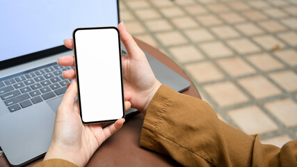 Close-up, Relaxed woman sitting outside, using a smartphone