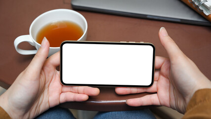 Female hands holding a smartphone in a horizontal position