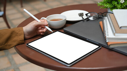 Female holding stylus pen with her right hand and drawing on tablet