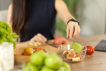 Woman preparing healthy food ingredients, chopping apples