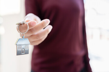 Woman holding keychains house key. Property investment and house mortgage financial real estate concept