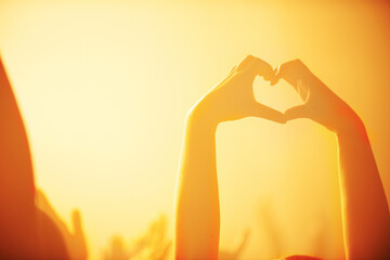 Pure love for music. Shot of a spectator making a heart shape with her hands at a rock concert.