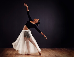 Elegance personified. Young female contemporary dancer using a soft white white skirt for dramatic...