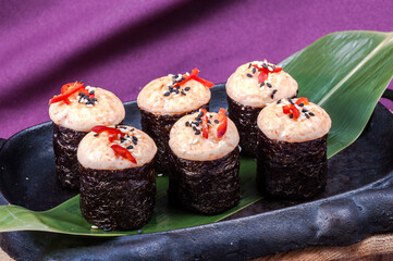 Delicious sushi on a green leaf in a cast-iron skillet.