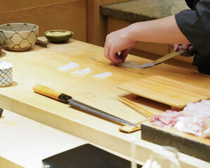 Chef use sharp knife slicing white  squid for sashimi.