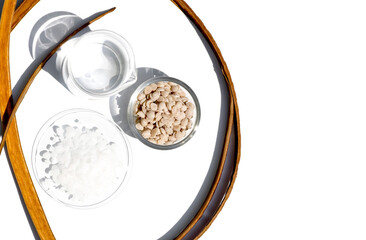 Sumac Wax in glass container and  Cetyl esters wax in chemical watch glass placed next to beaker. Chemical used in OTC products and topical pharmaceuticals.