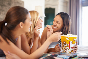 We havent done this in ages. Shot of three attractive young women eating popcorn on their girls...