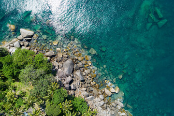 Aerial top view of sea waves crashing on rocks with coconut palm trees Beautiful seashore in Phuket Thailand Amazing nature seascape