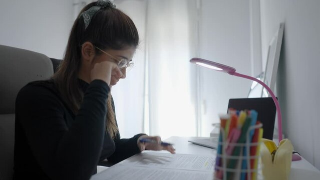 Focused young Colombian woman college university student doing homework assignment using laptop computer typing studying e learning on pc technology sit at home desk,distance online education concept.