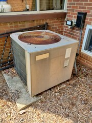 A very old air conditioning in need of replacement, exterior of home, condenser unit