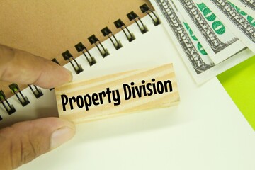 banknotes, notebooks and wooden boards with the word property division