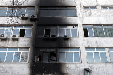 Burnt facade of building. Black walls after fire. Arson concept. Destroyed burned walls after fire extinguished.
