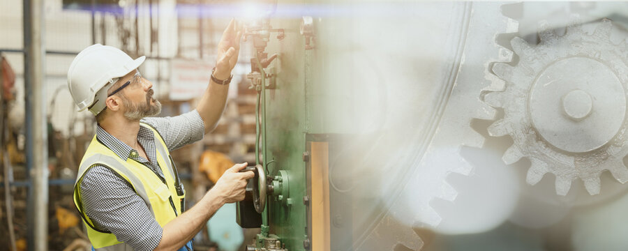 Engineer worker man working in heavy industry. Male staff with safety suit maintenance check factory machine overlay with metal gear.image wide banner size.