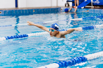 latin young man swimmer athlete wearing cap and goggles in a swimming training holding On Starting...