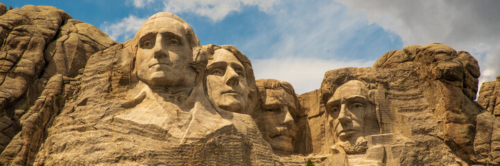 Iconic Mount Rushmore in South Dakota, United States of America. Taken in the summer on blue sky day with close up shot of Presidential faces.  - obrazy, fototapety, plakaty
