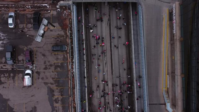 Crowd marching on street flyover from above railway Calgary Protest 12th Feb 2022