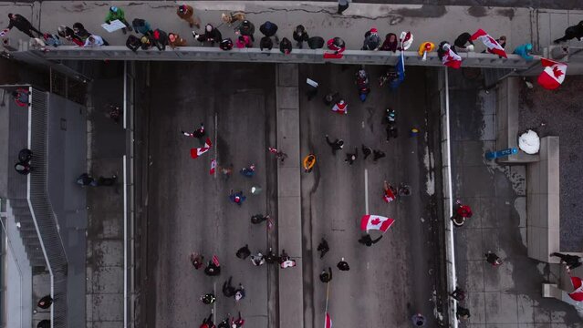 Crowd marching on street flyover bridge and railway tilt Calgary Protest 12th Feb 2022