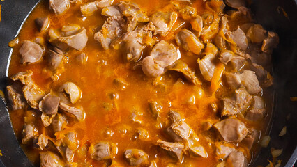 A top view of the wok with cooking chicken offal. Close-up. Asian-style cooking.