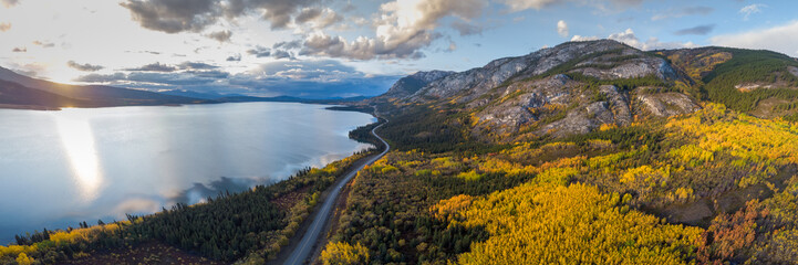 Amazing view from above in Yukon Territory during fall, autumn season with bright yellow spruce, birch and poplar trees covering the stunning mountains landscape. 