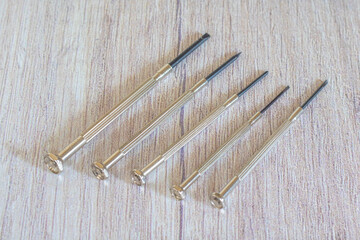 Different mini for delicate work on smallest screws in electronics and on wooden background